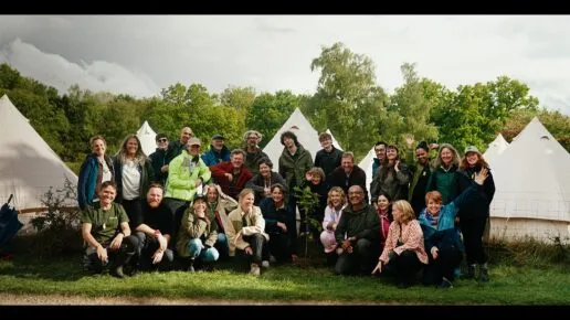 People posing infront of bell tents with trees in the background